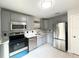 Updated kitchen with stainless steel appliances, gray cabinets, and modern countertops offers a sleek design at 3180 Owassa Ct, Kissimmee, FL 34746
