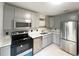 This modern kitchen features stainless steel appliances, gray cabinetry, and a clean, efficient layout at 3180 Owassa Ct, Kissimmee, FL 34746