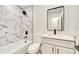 Updated bathroom with marble-look tile, white vanity, and black fixtures at 4401 Marshall St, Orlando, FL 32811