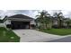 Exterior showcasing a well-maintained home with an open garage and meticulously landscaped yard at 7139 Cedarcrest Blvd, Lakeland, FL 33810