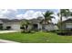 Exterior showcasing a well-maintained home with a manicured lawn, lush landscaping and mature palm trees at 7139 Cedarcrest Blvd, Lakeland, FL 33810