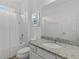 All-white bathroom with granite vanity, shower and tub combo at 6012 Oak Green Loop, Davenport, FL 33837