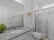 Bright bathroom featuring a granite countertop, white cabinets, and a glass-enclosed shower at 6012 Oak Green Loop, Davenport, FL 33837