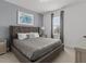 Bedroom with a large bed, gray headboard, and natural lighting from the window at 6012 Oak Green Loop, Davenport, FL 33837