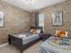 The bedroom features exposed brick wallpaper, two twin beds with Harry Potter decor, and cozy bedding at 6012 Oak Green Loop, Davenport, FL 33837