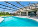 A screened-in pool with a hot tub has a partially fenced barrier for safety, offering a perfect outdoor retreat at 6012 Oak Green Loop, Davenport, FL 33837