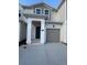 Two-story house with gray siding, attached garage, and covered entryway at 7673 Stone Creek Trl, Kissimmee, FL 34747