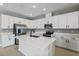 Modern kitchen with white cabinets, quartz countertops, and stainless steel appliances at 914 Heirloom Dr, Haines City, FL 33844