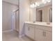 Double vanity bathroom with white cabinets and shower at 918 Heirloom Dr, Haines City, FL 33844