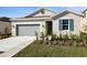 Tan house with gray garage door and teal shutters at 918 Heirloom Dr, Haines City, FL 33844