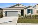 Tan house with gray garage door and teal shutters at 918 Heirloom Dr, Haines City, FL 33844