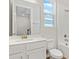 Bright bathroom features a white vanity, a shower-tub combo with white tile, and a window at 1635 Sugarbelle Cir, Mascotte, FL 34753