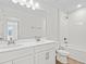 Bathroom featuring double sinks, white cabinets and tiled bathtub shower combo at 1635 Sugarbelle Cir, Mascotte, FL 34753