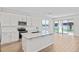 Bright, modern kitchen with a central island, stainless steel appliances, and access to the outdoors at 1635 Sugarbelle Cir, Mascotte, FL 34753