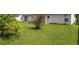 Simple backyard with grassy lawn and a flowering bush at 2419 Willow Tree Ln, Kissimmee, FL 34758