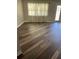 Living room with hardwood floors and large windows with curtains at 11460 Chateaubriand Ave, Orlando, FL 32836