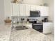 Well-equipped kitchen featuring granite countertops and white cabinets at 8545 Bay Lilly Loop, Kissimmee, FL 34747