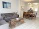 Open living room and dining area with grey sofa and wooden dining table at 8545 Bay Lilly Loop, Kissimmee, FL 34747