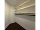 Walk-in closet with built-in shelving and dark wood floor at 300 New Waterford Pl # 204, Longwood, FL 32779