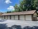 A row of individual garages with white doors and brick accents against a blue sky at 300 New Waterford Pl # 204, Longwood, FL 32779