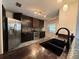 Beautiful kitchen featuring stainless steel appliances, dark wood cabinetry, and unique tile backsplash at 300 New Waterford Pl # 204, Longwood, FL 32779