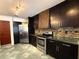 This kitchen features dark wood cabinetry, stainless steel appliances, and uniquely tiled backsplashes at 300 New Waterford Pl # 204, Longwood, FL 32779