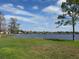 Scenic lake view featuring a lush green lawn, trees, and a serene body of water on a sunny day at 300 New Waterford Pl # 204, Longwood, FL 32779