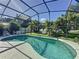 Enjoy a private screened-in pool surrounded by lush landscaping with a seating area at 3075 Barbados Ln, Haines City, FL 33844