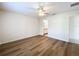 Bedroom features wooden floors, a ceiling fan, neutral walls, and a view into the bathroom at 167 Bell Tower Xing W, Poinciana, FL 34759