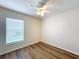 Bright bedroom with modern ceiling fan, large window, and clean hardwood floors offering a peaceful and airy ambiance at 167 Bell Tower Xing W, Poinciana, FL 34759