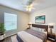 Well-lit bedroom features a large bed, modern ceiling fan, and stylish decor, creating a cozy and inviting space at 167 Bell Tower Xing W, Poinciana, FL 34759