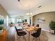 Open-concept dining room featuring a light wood table with seating for six and seamless flow into the living area at 167 Bell Tower Xing W, Poinciana, FL 34759