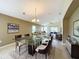 Open-concept dining room featuring a glass table with seating for six and seamless flow into the living area at 167 Bell Tower Xing W, Poinciana, FL 34759