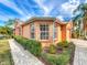 Close-up of the exterior with manicured landscaping, garden beds and a paver walkway that accents the facade at 167 Bell Tower Xing W, Poinciana, FL 34759