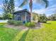 Charming exterior view of the screened patio, surrounded by lush landscaping at 167 Bell Tower Xing W, Poinciana, FL 34759