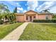 Inviting single-story home featuring well-maintained lawn, landscaping, and a brick walkway leading to the front entrance at 167 Bell Tower Xing W, Poinciana, FL 34759
