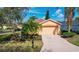 Home featuring an attached two-car garage, brick-paved driveway, and mature landscaping, providing curb appeal at 167 Bell Tower Xing W, Poinciana, FL 34759