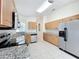 Bright kitchen with stainless steel appliances, granite countertops, and tile flooring at 167 Bell Tower Xing W, Poinciana, FL 34759