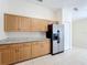 Kitchen features stainless steel refrigerator, granite countertops and tiled flooring at 167 Bell Tower Xing W, Poinciana, FL 34759