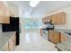 Functional kitchen featuring oak cabinetry, granite countertops, stainless steel appliances, and a breakfast nook at 167 Bell Tower Xing W, Poinciana, FL 34759