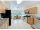 Well-lit kitchen featuring oak cabinetry, granite countertops, stainless steel appliances, and a breakfast nook at 167 Bell Tower Xing W, Poinciana, FL 34759