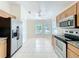 Bright kitchen featuring oak cabinetry, granite countertops, stainless steel appliances, and a breakfast nook at 167 Bell Tower Xing W, Poinciana, FL 34759