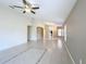 Expansive living room area featuring tile flooring, arched entryways, and neutral tones with a ceiling fan at 167 Bell Tower Xing W, Poinciana, FL 34759