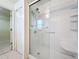 Shower with glass door, updated fixtures, and a built-in shelf, blending style and practicality, open to closet at 167 Bell Tower Xing W, Poinciana, FL 34759