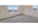 Bedroom with neutral walls, grey carpet, and two windows at 2918 Sharp Rd, Kissimmee, FL 34744