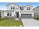 Two-story house with gray garage and landscaping at 2918 Sharp Rd, Kissimmee, FL 34744