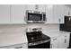 Stainless steel appliances and white cabinetry in the kitchen at 2918 Sharp Rd, Kissimmee, FL 34744