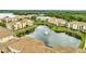 Aerial view featuring a pond with a fountain and surrounding apartments with red tile roofs at 1100 Lake Shadow Cir # 2101, Maitland, FL 32751