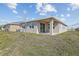 The backyard features a covered patio, sliding glass doors, lawn, and the rear exterior of the home at 636 Hennepin Loop, Lake Wales, FL 33898