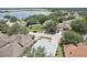 Aerial view of home in tree-lined neighborhood near a large lake at 1404 Longville Cir, Tavares, FL 32778